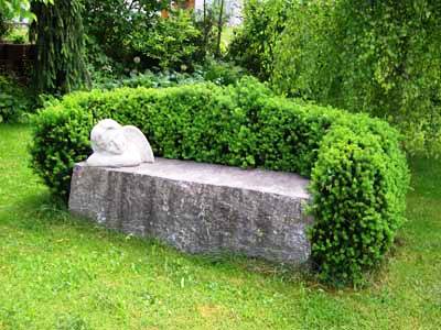 Sitzbank einmal anders - als Sitzfläche dient ein massiver Steinblock und die Rücken- und Armlehnen sind lebendig